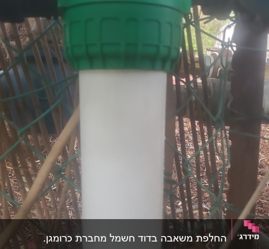 מסנן מים עם מכסה ירוק מחובר לצינור